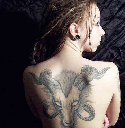 Tatuaje de un animal cornudo con los ojos en blanco que esta chica con rastas se ha tatuado sobre toda su espalda, destaando lo bien conseguido que están tanto los detalles de los cuernos, con las rallas empleadas para hacer un buen pelaje al animal Tatuaje de un animal cornudo con los ojos en blanco que esta chica con rastas se ha tatuado sobre toda su espalda, destaando lo bien conseguido que están tanto los detalles de los cuernos, con las rallas empleadas para hacer un buen pelaje al animal