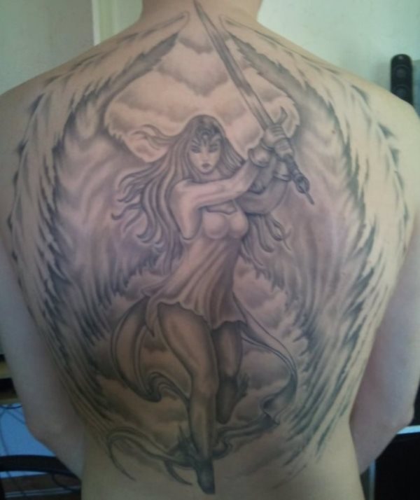 Tatuaje de un ángel con poca ropa y grandes alas, que como podemos observar se encuentra el posición de guardia con una gran espada entre sus manos