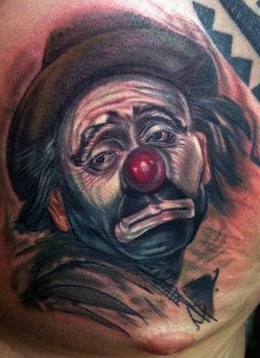 Triste y realista tatuaje de payaso en el que las arrugas de la cara y la barba de un par de días le dan ese toque de realismo que lo perfecciona la nariz y sus brillos, lástima que esté tan triste el payaso porque con ese tatuaje tan bien conseguido es para estar muy alegre