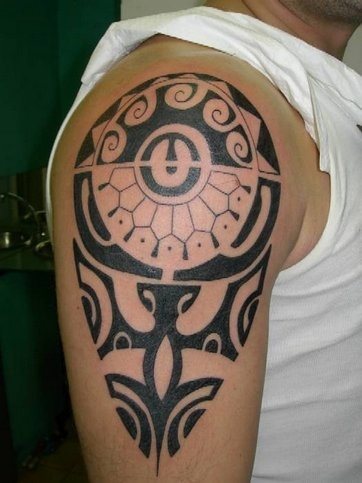Tatuaje maori en color negro y que da el aspecto de flecha o púa, a la par que resaltan el músculo del hombro y del bíceps, un tatuaje con un tamaño muy acertado que poder lucir en multitud de ocasiones