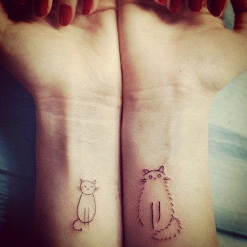 Dos gatos tatuados en las muñecas