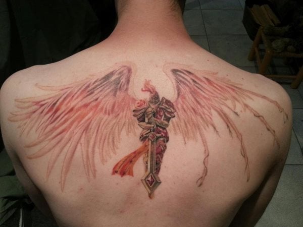Tatuaje de un guerrero con armadura y unas enormes alas de color rojo tostado y sombreado negro, un fino y delicado tattoo que ha quedado muy bien, pero que rozaría la perfección si se hubiera marcado algo más el plumaje de las alas