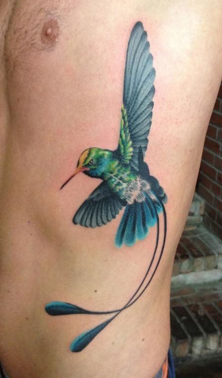 Sitio perfecto, dibujo perfecto y colores perfectos harán que tengas un gran tatuaje como es este caso, en el que el pájaro en pleno vuelo dan una forma ideal al costado de este hombre