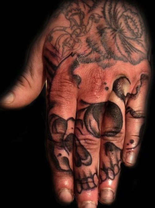 En este caso la calavera est tatuada sobre los dedos y se ve completa al juntarlos