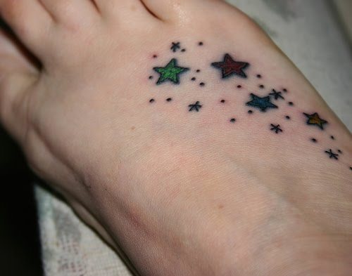 Surco de pequeñas estrellas en distintos colores sobre el empeine, un tattoo muy utilizado en los últimos años y que es el tatuaje perfecto para todas aquellas personas que quieren hacerse un tatuaje, pero quieren que sea pequeño y disimulado