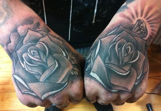 Dos grandes rosas es el tatuaje elegido por este hombre, en el que podemos ver se ha dibujado arriba de una rosa un diamante con destellos difuminados y en la rosa de la otra mano, se ha colocado un escondido corazón junto a unas pequeñas nubes