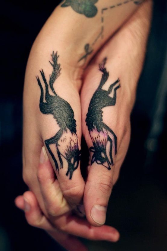 Dos lobos tatuados en ambos dedos pulgares de la mano