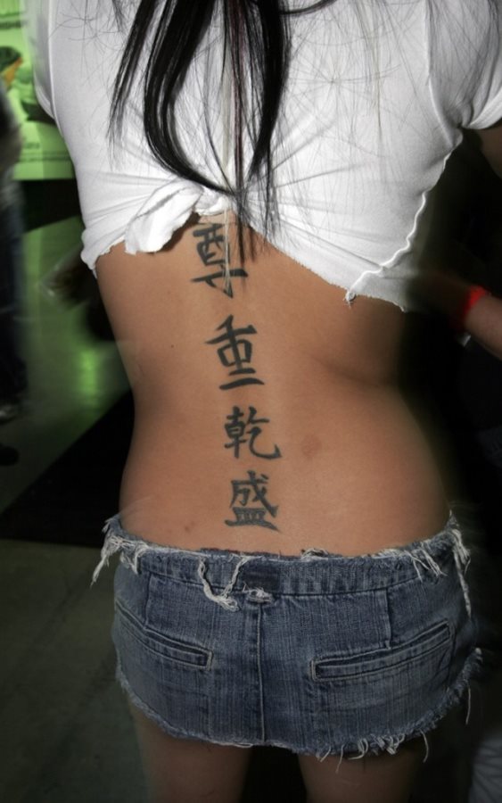 Tatuaje de letras chinas en la espalda, que van recorriendo toda la espalda en la parte de la columna vertebral, como el chino aún no lo dominamos, no os podemos decir qué significa, pero parece que esa es la idea que algunos tienen cuando se tatúan letras chinas, el que no todos podamos traducir facilmente el significado del tattoo
