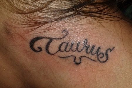 Tatuaje en el cuello con la palabra Taurus, el signo zodiacal para los nacidos entre finales de abril y de mayo, que simboliza la consolidación y cuyo símbolo representa la cabeza de un toro con astas circulando a su alrededor