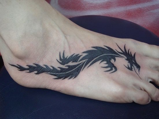 Silueta de un dragón de estilo tribal situado sobre el pie