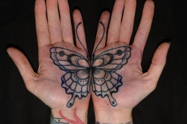 Mariposa sobre las palmas de las manos que necesitan unirse las manos para que se vea el tatuaje completo, si os fijáis estáis ante una buena idea de tatuaje para dos personas distintas, que cada una se podría tatuar una parte del tatuaje y al unirse cada persona se viera el tatuaje al completo